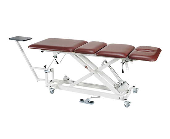 Armedica AM-SX 4000 treatment table, four-section top, brown pad, white frame, on wheels.