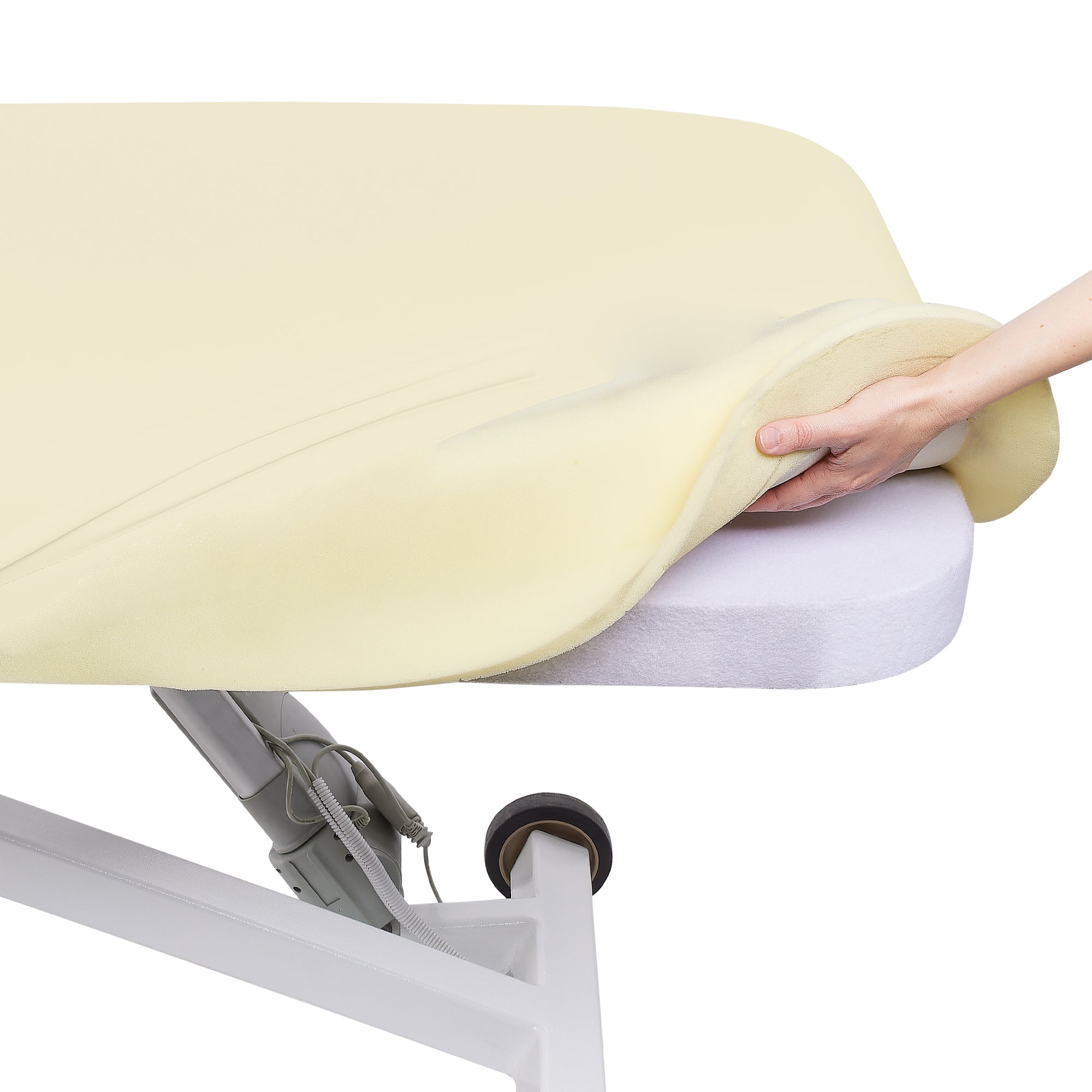 Hand lifting an Earthlite ELLORA LX FLAT mattress from a white adjustable treatment table.