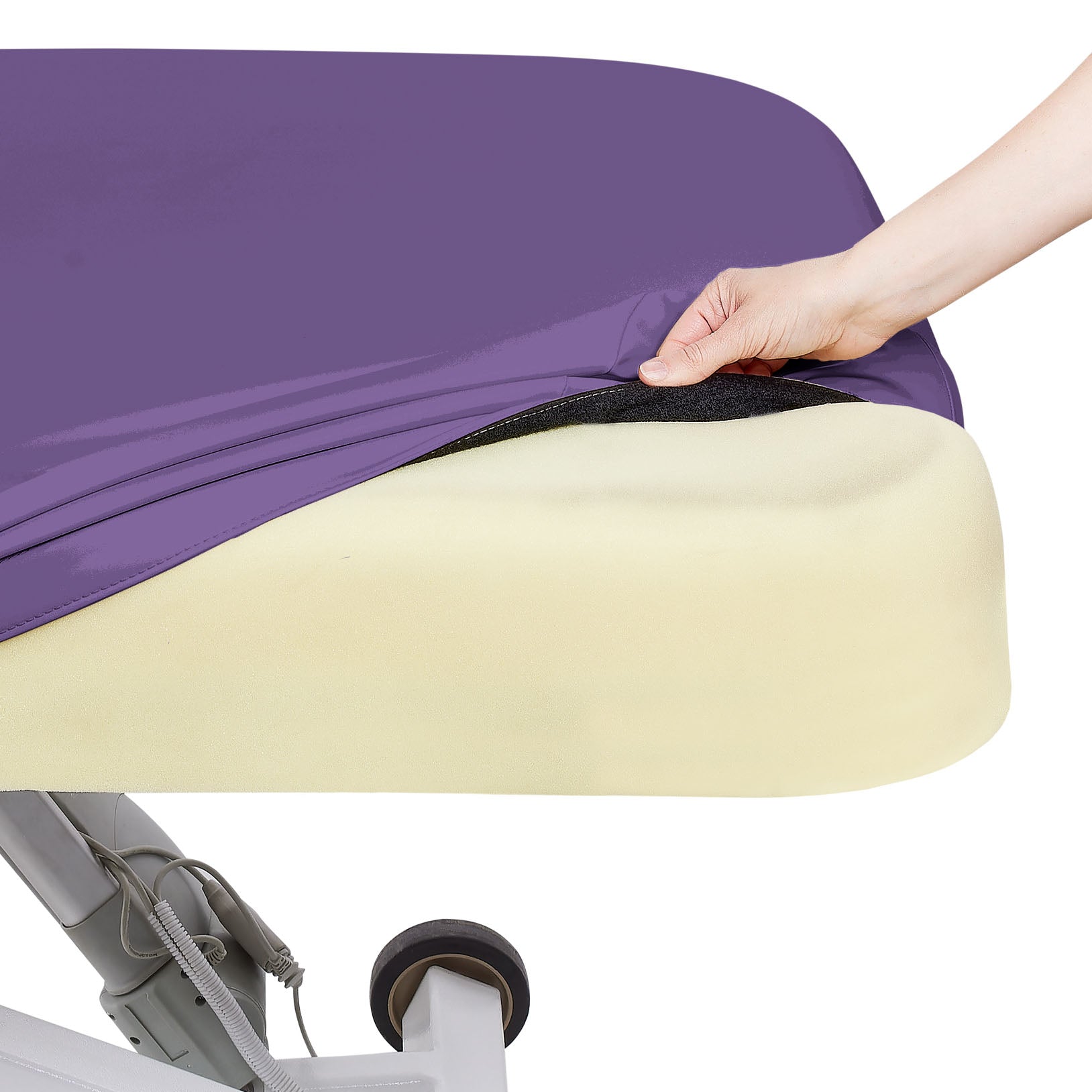 Hand lifts purple cover from yellow foam mattress on EarthLite ELLORA LX TILT Treatment Table.
