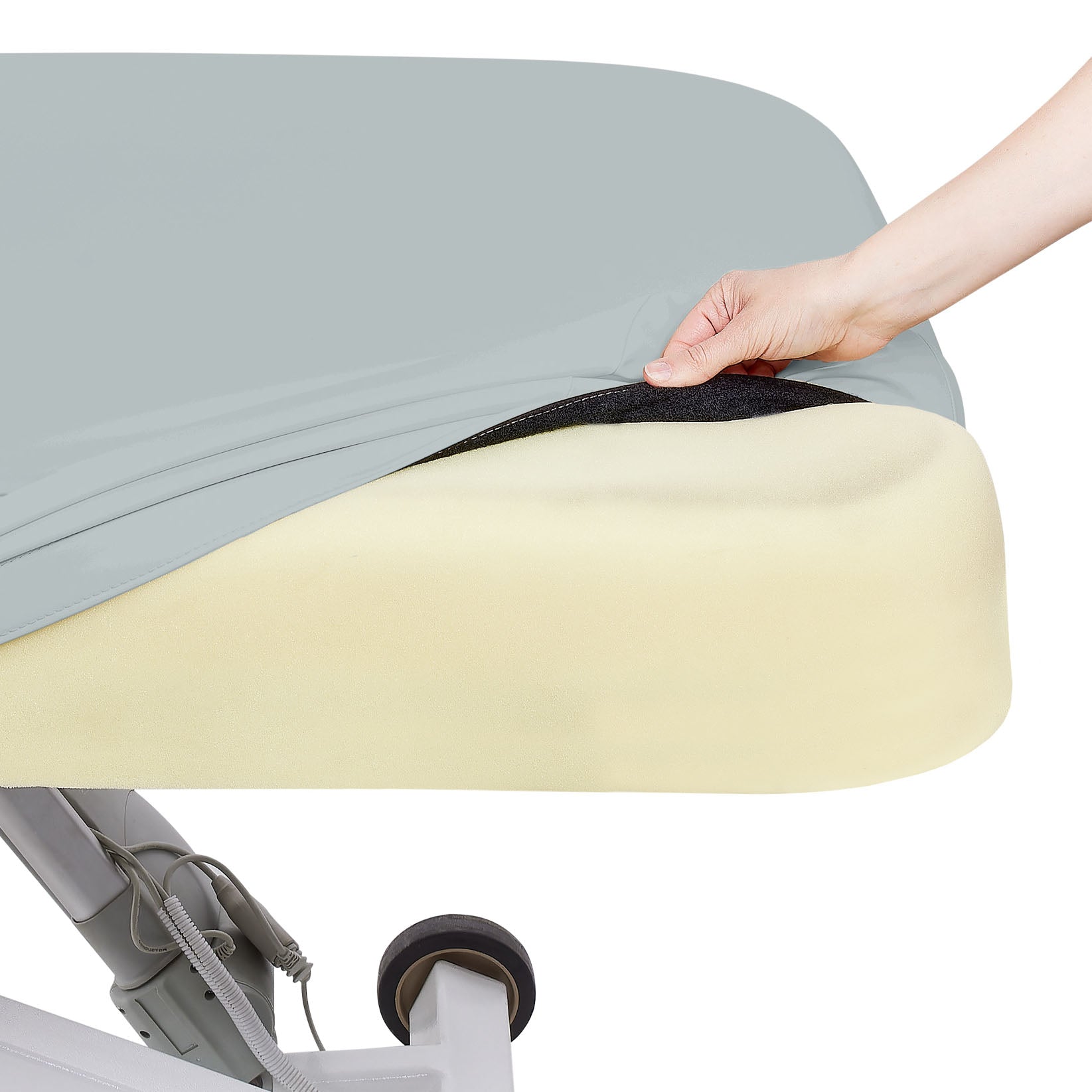 Hand lifts gray cover, revealing foam padding on the EarthLite ELLORA LX TILT massage table.