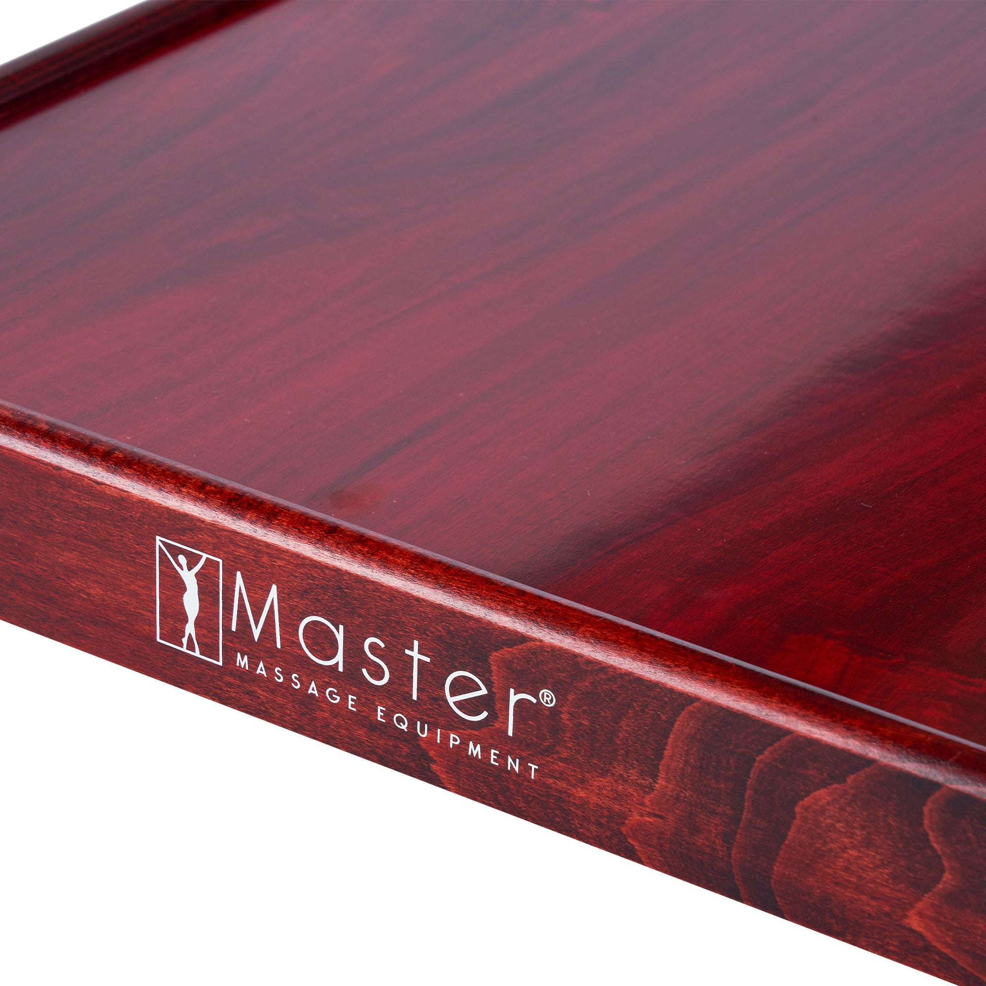 Close-up of a wooden tray with Master Massage logo next to AirMaster Stationary Massage Table.