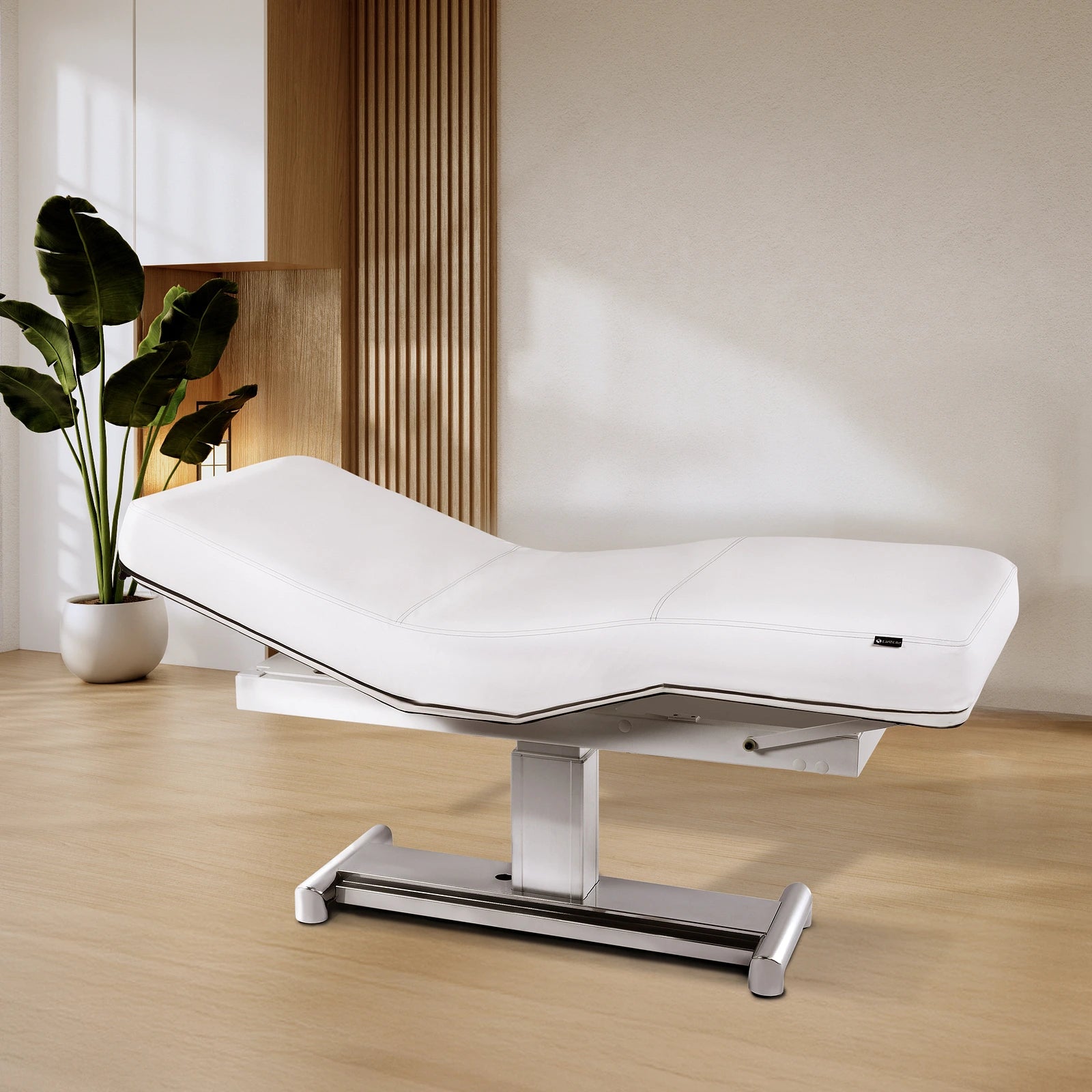 EarthLite EVEREST LX Treatment Table with replaceable mattress in a wood-accented spa.