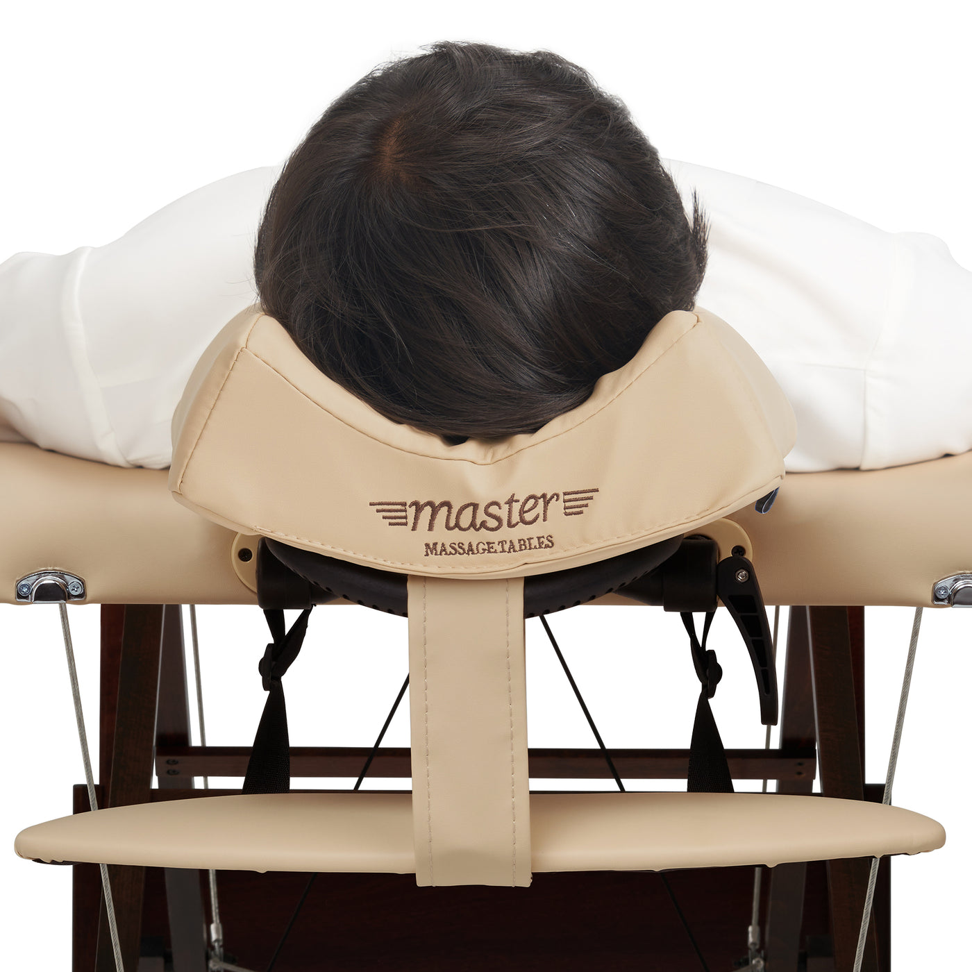 Person using a beige massage table with 'master' branding on a white background