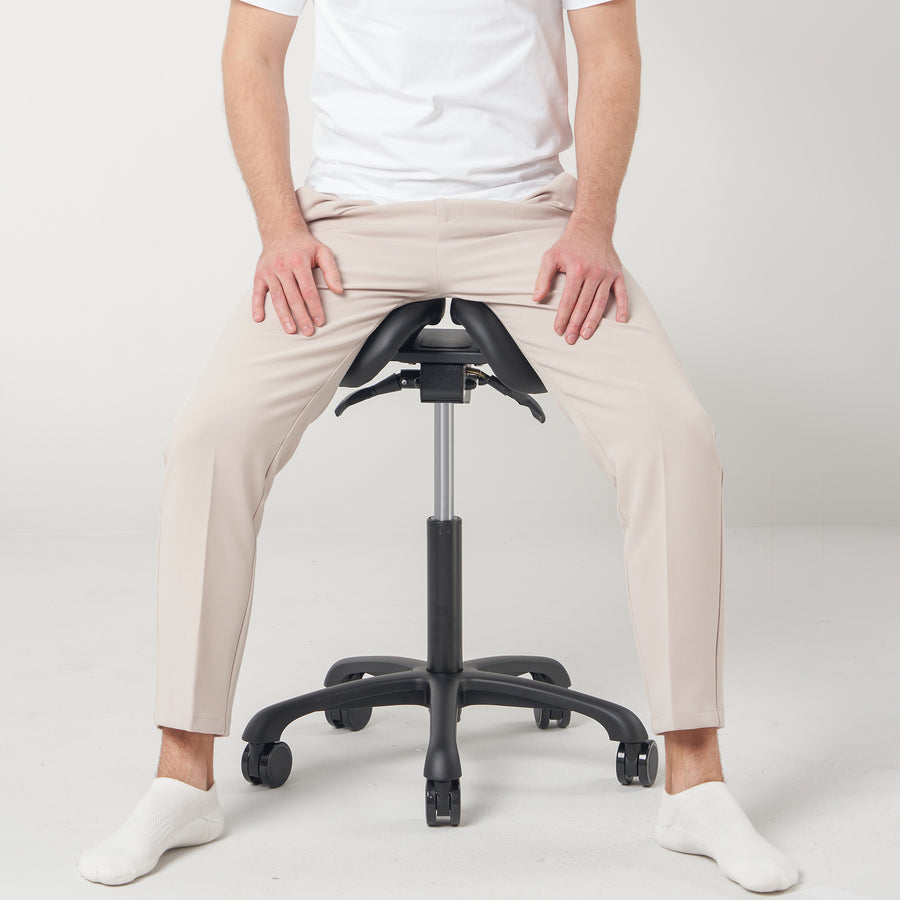 Person sitting on Master Massage Berkeley Ergonomic Posture Saddle Chair with a plain white background