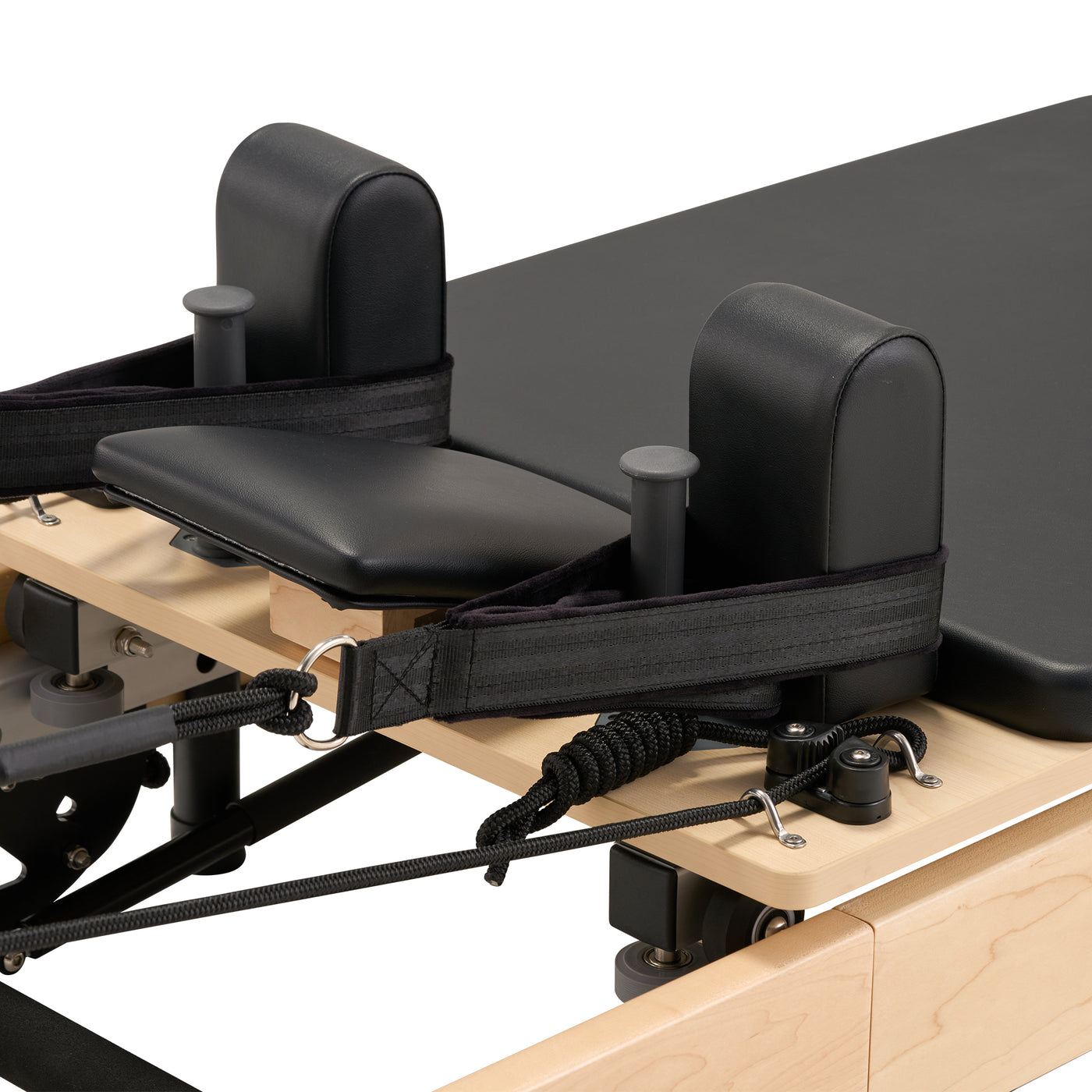Pilates reformer machine with black cushioned seat and handles on a white background