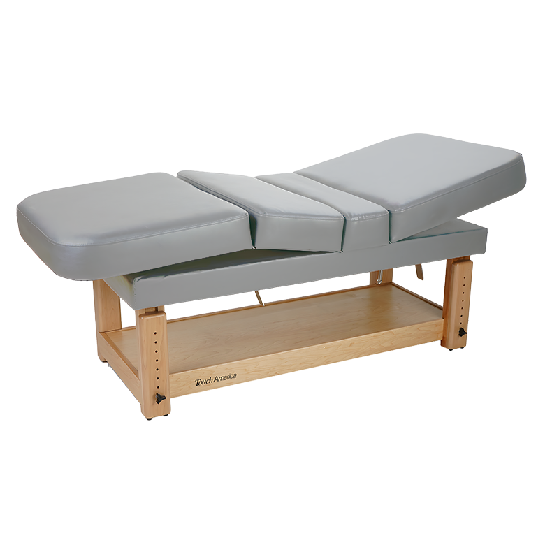 TouchAmerica STATIONARY MULTIPRO Treatment Table with wooden base and shelf, gray finish.