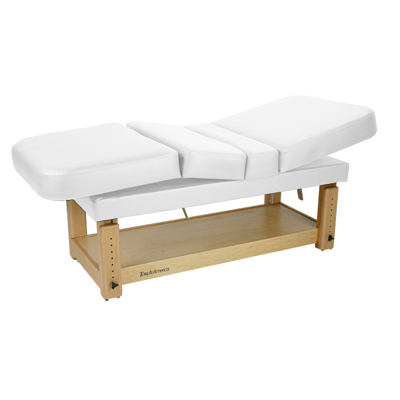 TouchAmerica STATIONARY MULTIPRO Treatment Table with wooden base and storage shelf.