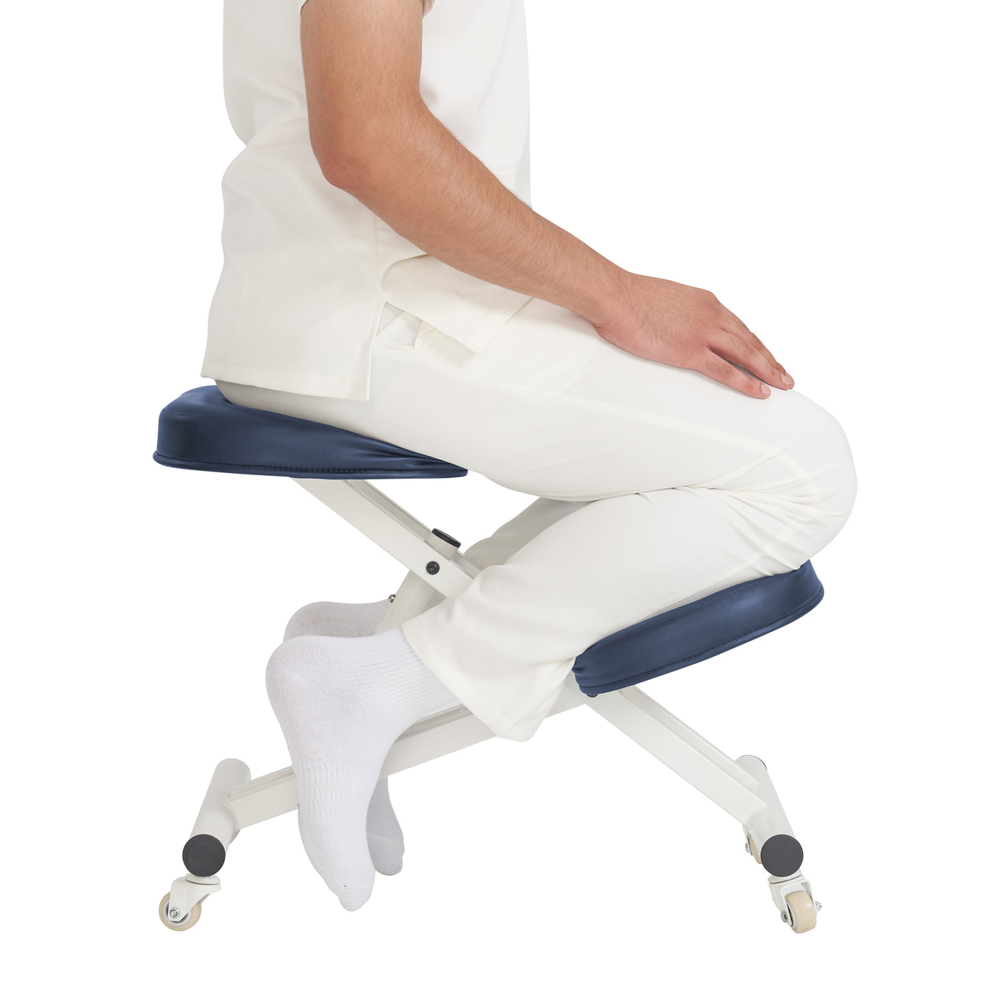 Person sitting on a royal blue kneeler chair with white pants on a white background
