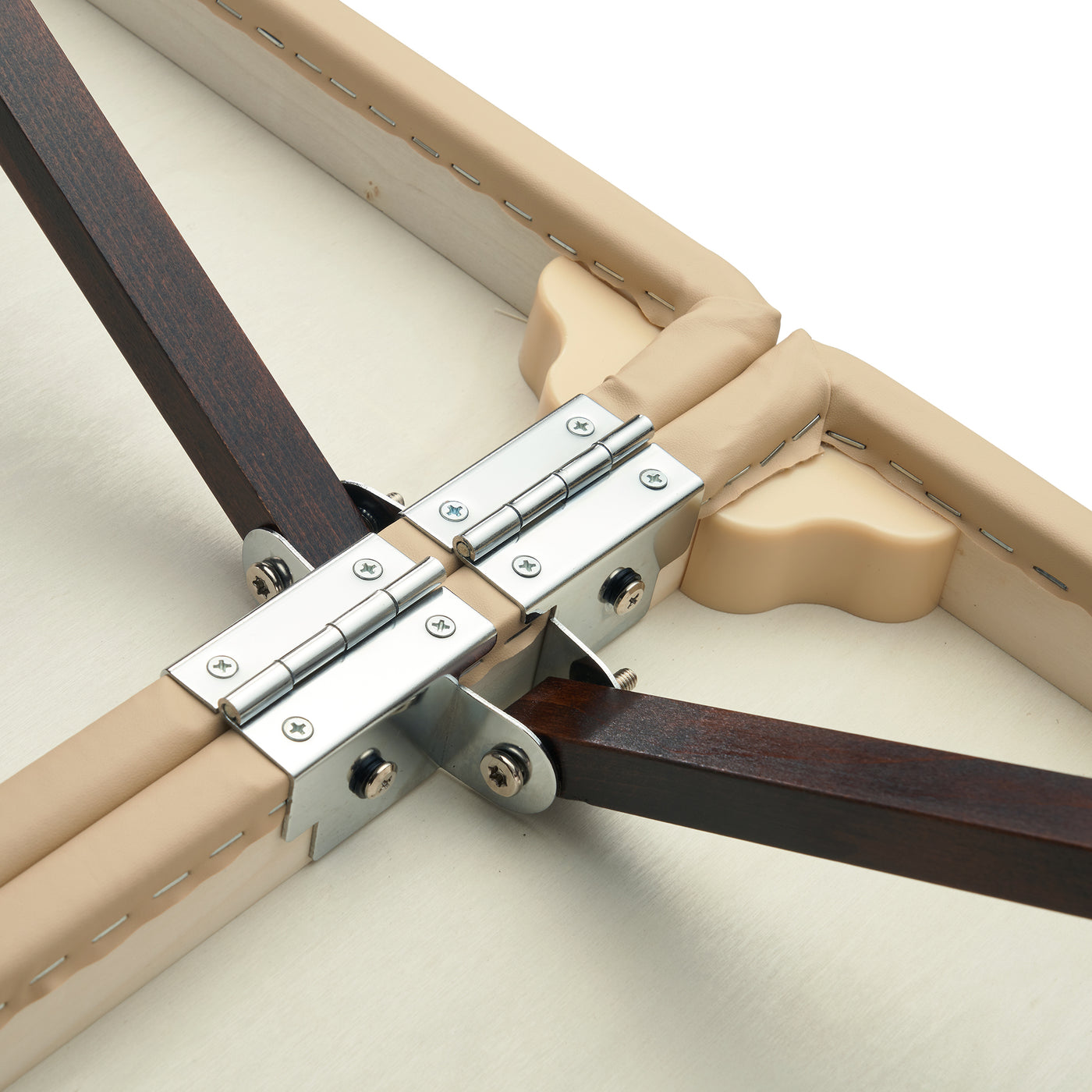 Close-up of metal hinges on wooden legs of the Master Massage ARGO Portable Table in cream.