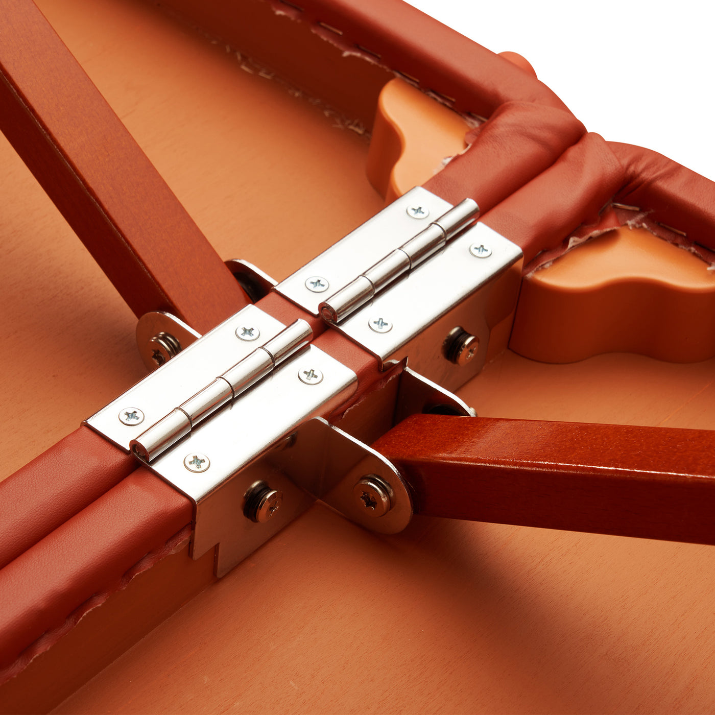 Close-up of Master Massage FAIRLANE SPORTS table hinges, orange padding, and auto-lock legs.