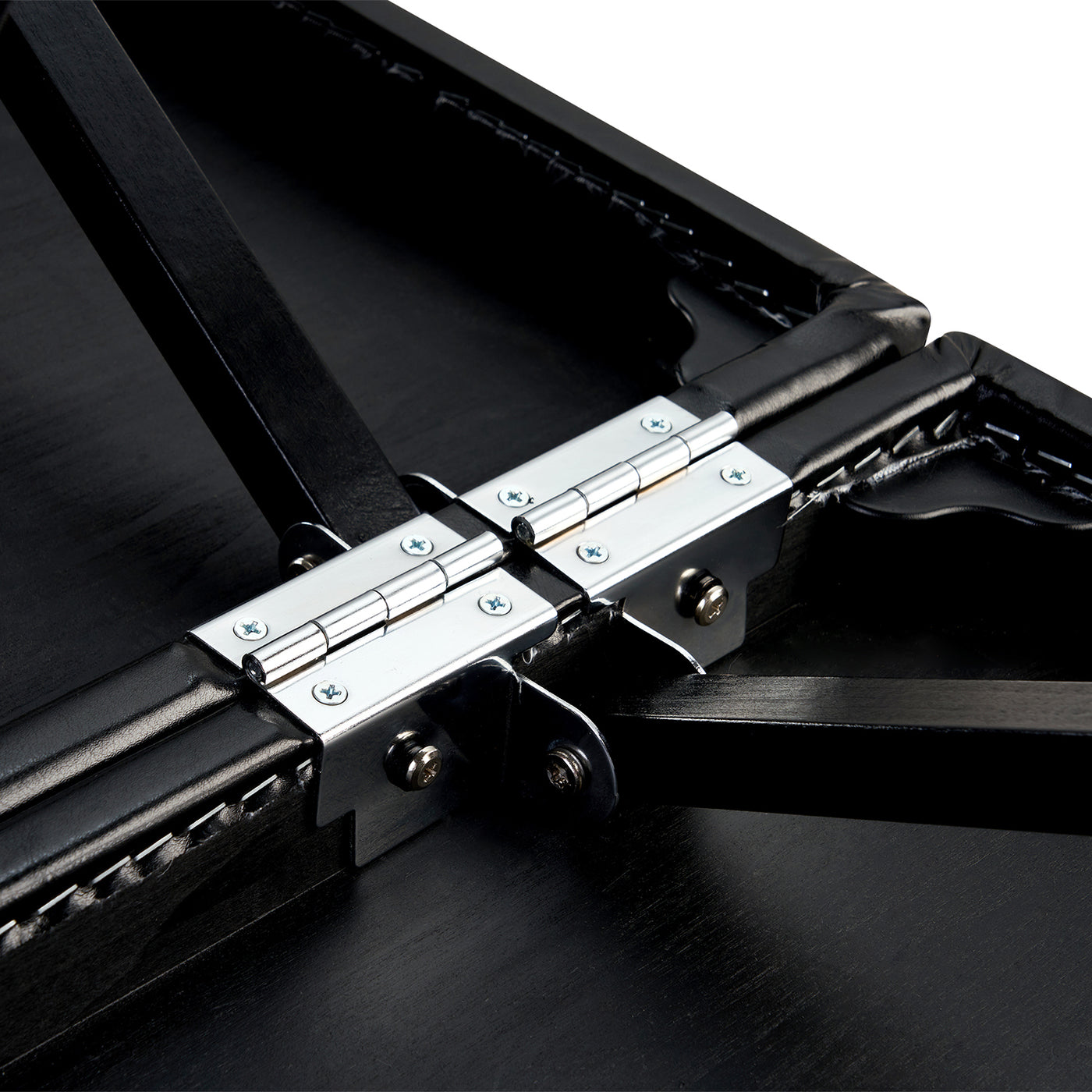 Close-up of a hinge on the Master Massage GALAXY Therma-Top table’s black wooden surface.
