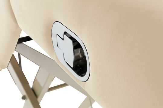 Close-up of a beige massage table with a metallic handle.