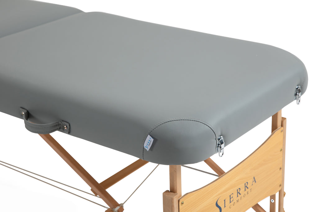 Sierra Comfort Premium Wide Portable Massage Table with wooden legs and gray padding.