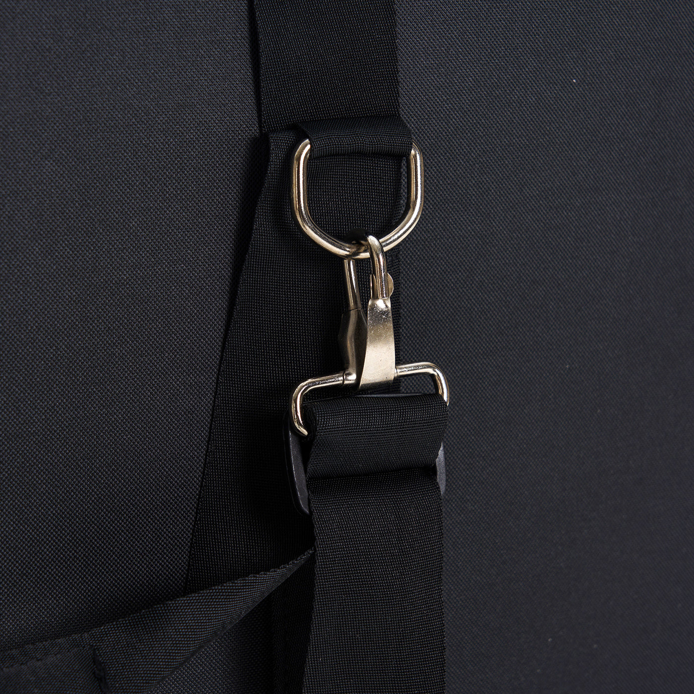 Close-up of a black bag with a metal buckle on a black background