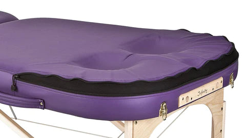 Earthlite ELLORA LIFT Massage Table with face cradle cutout and light wood legs.