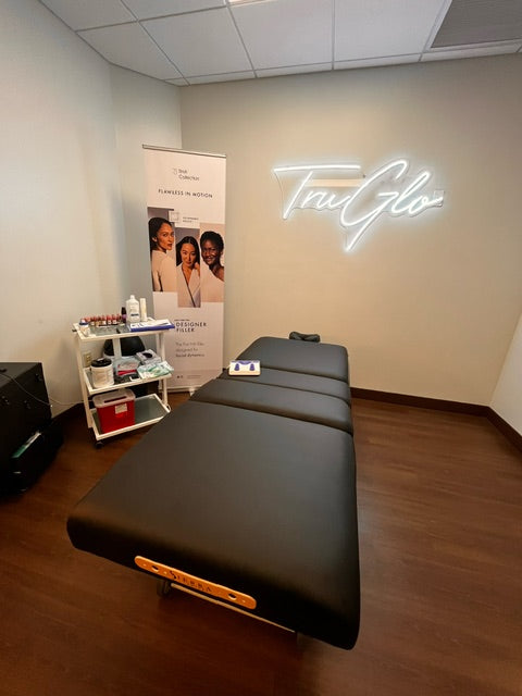 Sierra Comfort Adjustable 4-Section Electric Lift Table in a modern room with TruGlo neon sign.