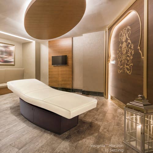 Modern spa room with a Living Earth Crafts INSIGNIA 2.0 HORIZON table, wood accents, and soft lighting.