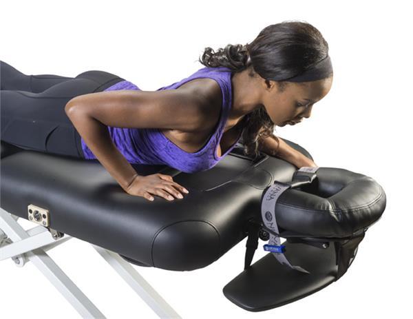 Woman on Nirvana Salon Top Electric Massage Table, ready to place face in the headrest.