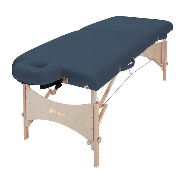 EarthLite HARMONY DX portable massage table with wooden legs and navy blue padded surface.