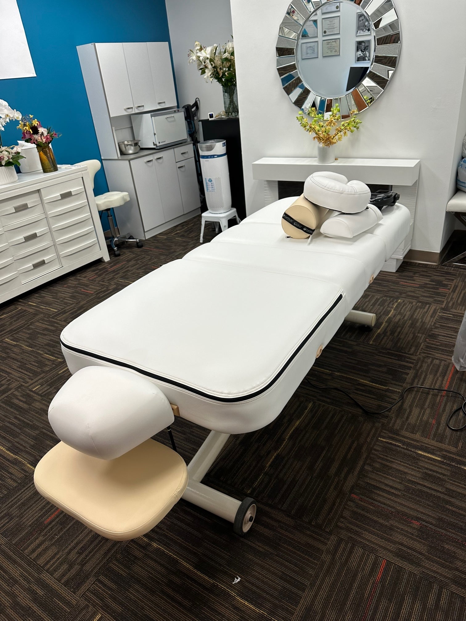 EarthLite Ellora Vista Full Electric Salon Table with white cushions and salon headrest in use.