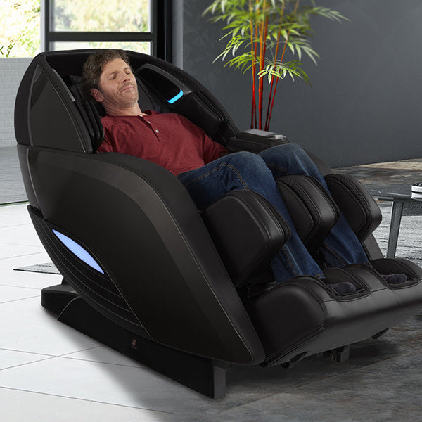 Man relaxing in a Kyota Yutaka M898 4D Massage Chair (Certified Preowned) in a modern living room.