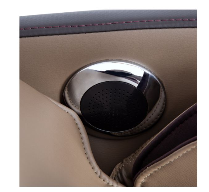 Close-up of a round speaker in beige and brown Titan PRO COMMANDER massage chair upholstery.