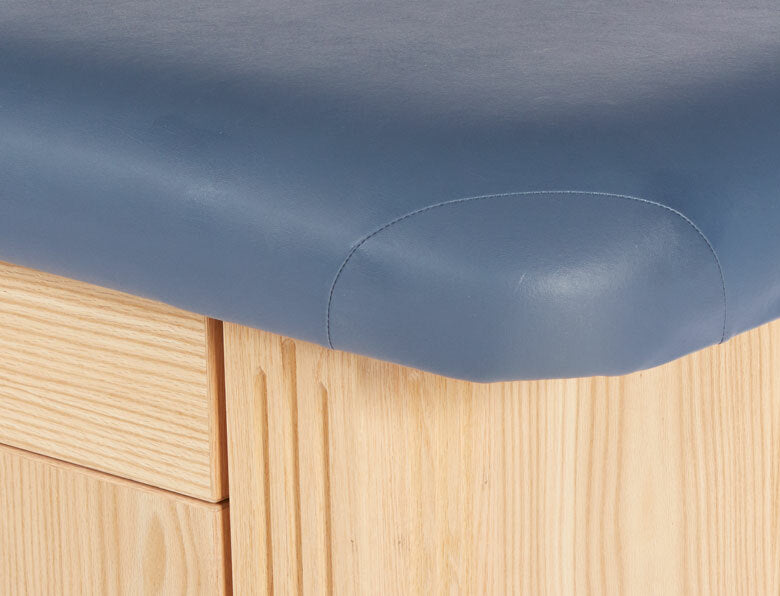 Corner of the Custom Craftworks M100 Deluxe Electric Spa Table with blue cushion and wood finish.