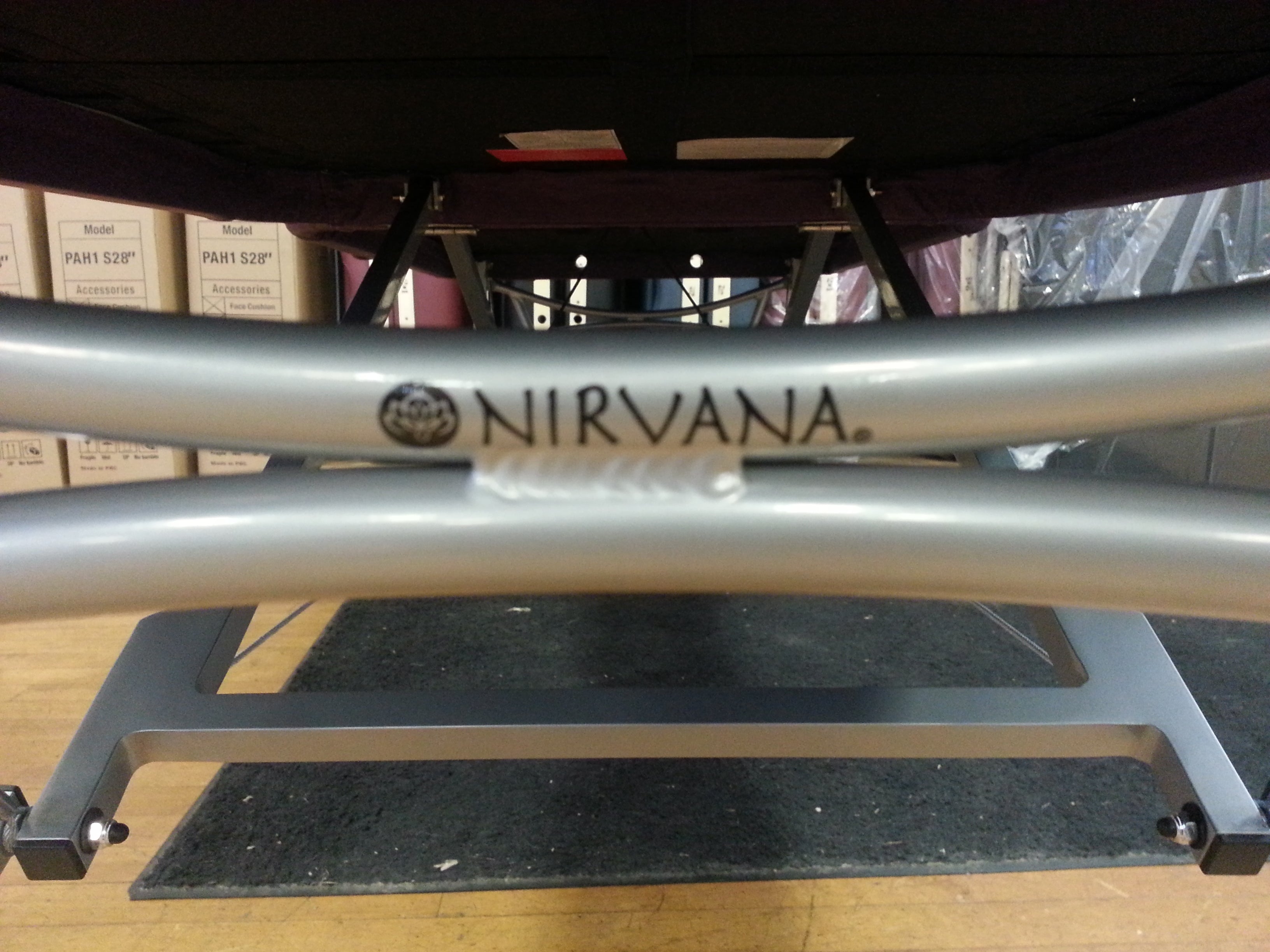 Close-up of the Nirvana DHARMA SuperLite Massage Table's aluminum frame with black Nirvana branding.
