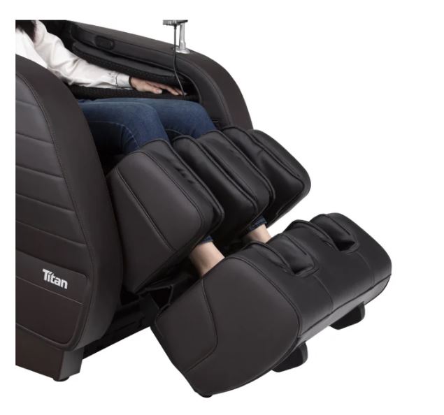 A person relaxes in a black Titan JUPITER LE Premium Electric Massage Chair by Titan.