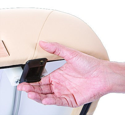 A hand adjusts a black latch on a beige Living Earth Crafts NAPA spa table with hydraulic lift.