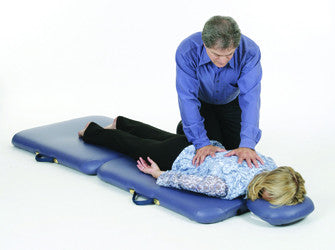 Person giving chest compressions to another on a Pisces Pro NEW WAVE II Lite massage table.