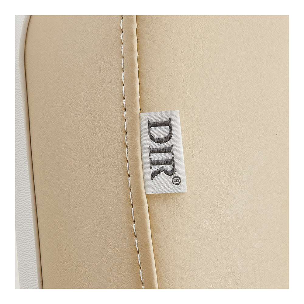 Close-up of Libra II Beige Medical Chair’s stitched leather seam with DIR-branded white tag.