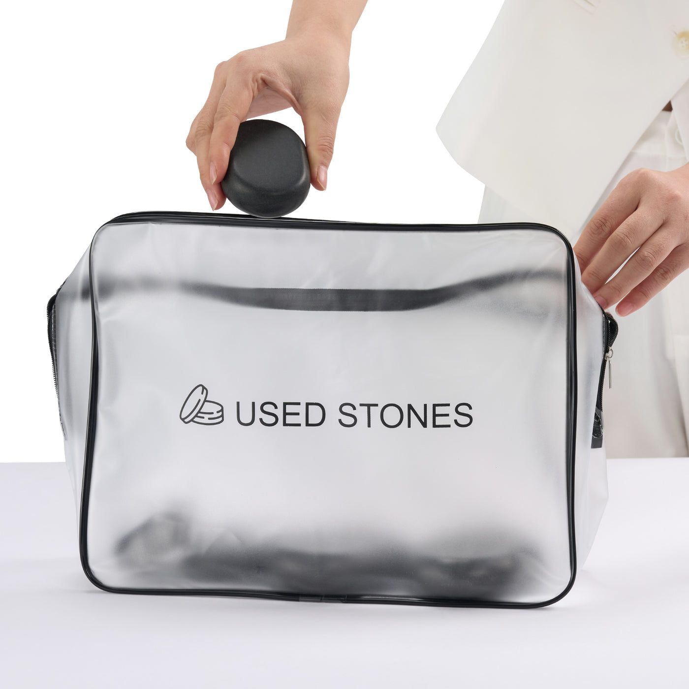 Clear pouch with 'USED STONES' branding held by a person on a white background
