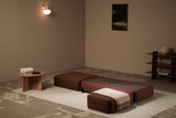 Brown Ceragem S4 Massage Lounger in a minimalistic room with a rug and small table.