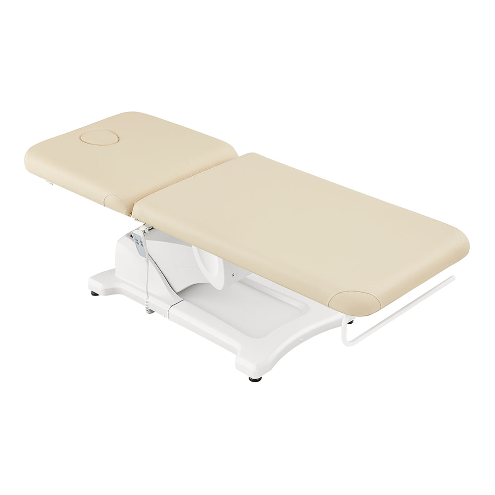 Serenity Electric Treatment Table by DIR, beige with white base and headrest cutout.