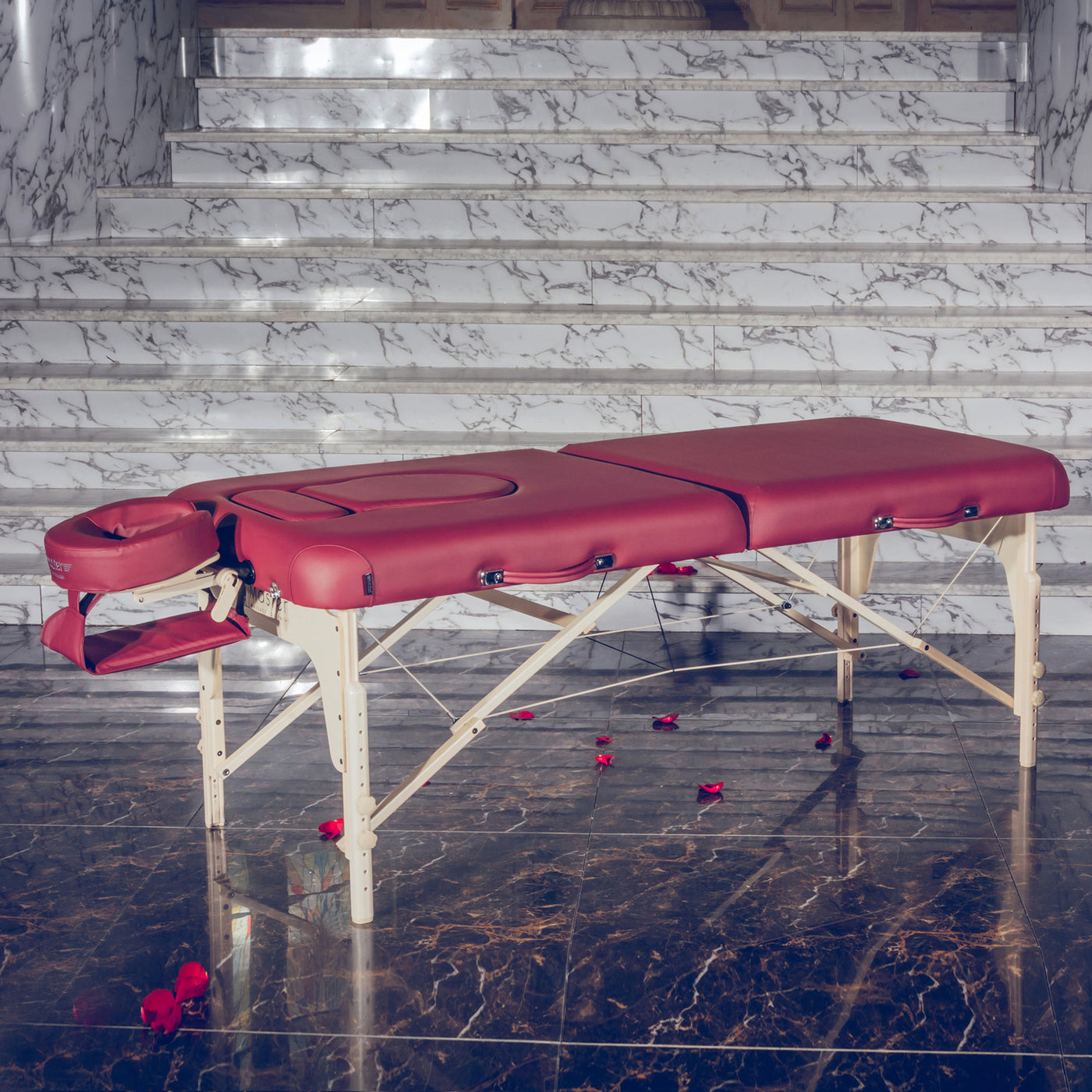 The Master Massage EVA PREGNANCY table stands on marble, rose petals by the marble stairs.