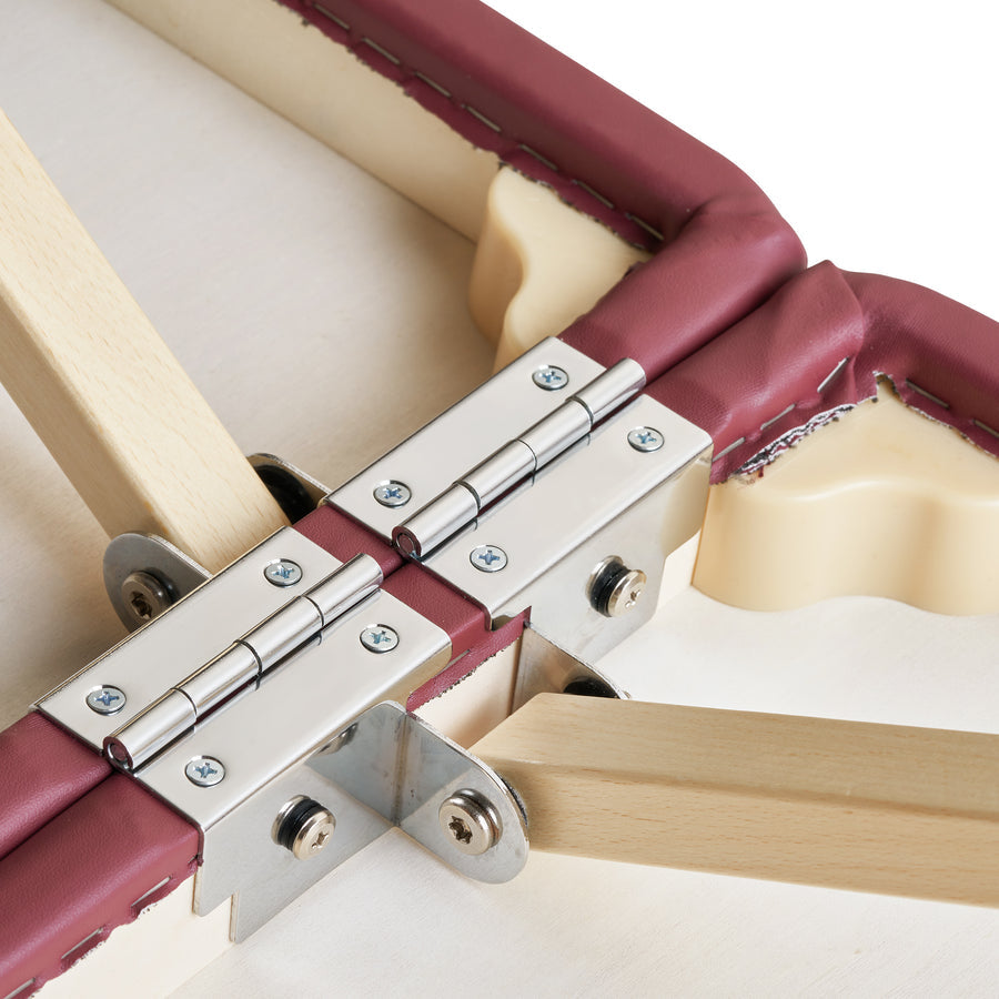 Close-up of Master Massage EVA PREGNANCY table hinges on wood frame with maroon padding.