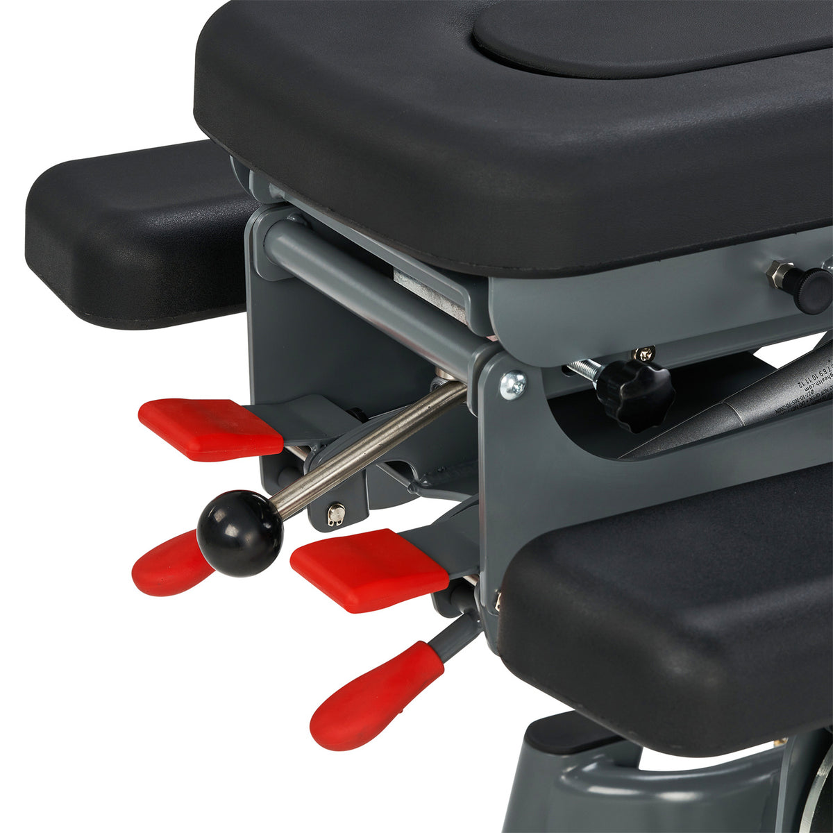 Close-up of a mechanical device with red levers and a black seat on a white background