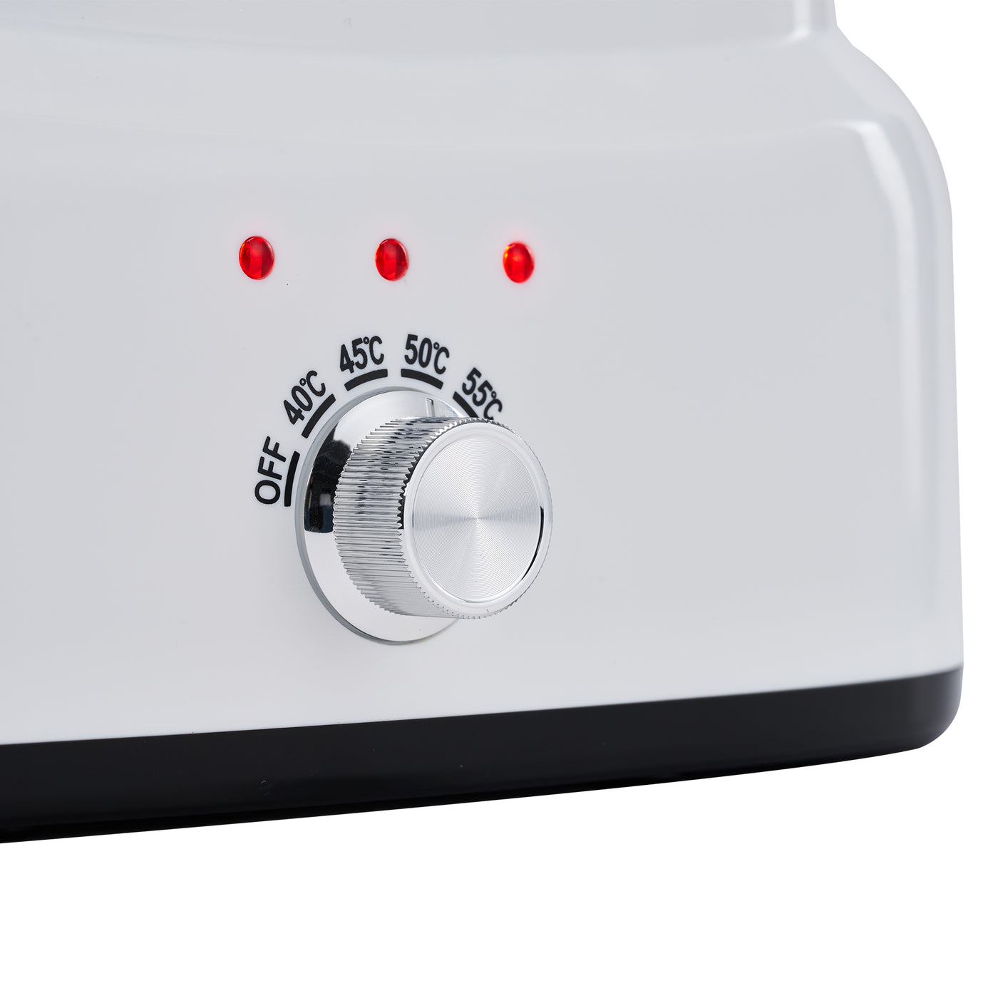 Temperature control knob on a white appliance with red indicator lights.
