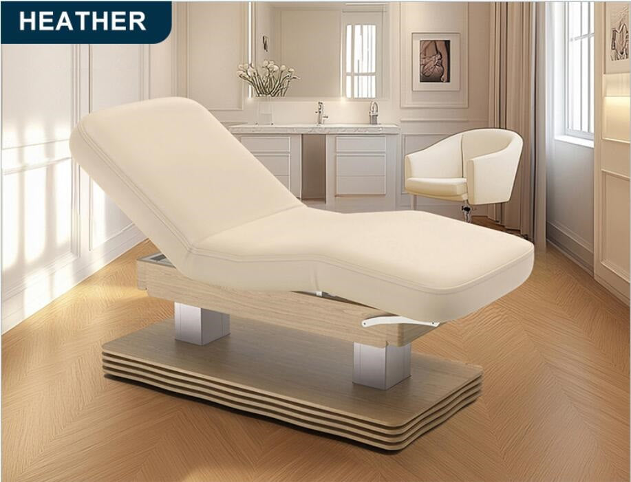 Beige massage table in a spa setting with 'HEATHER' branding.