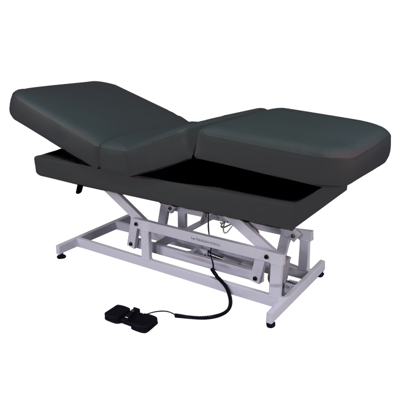 TouchAmerica HILO MULTIPRO Treatment Table with dark cushions and foot pedal controls.