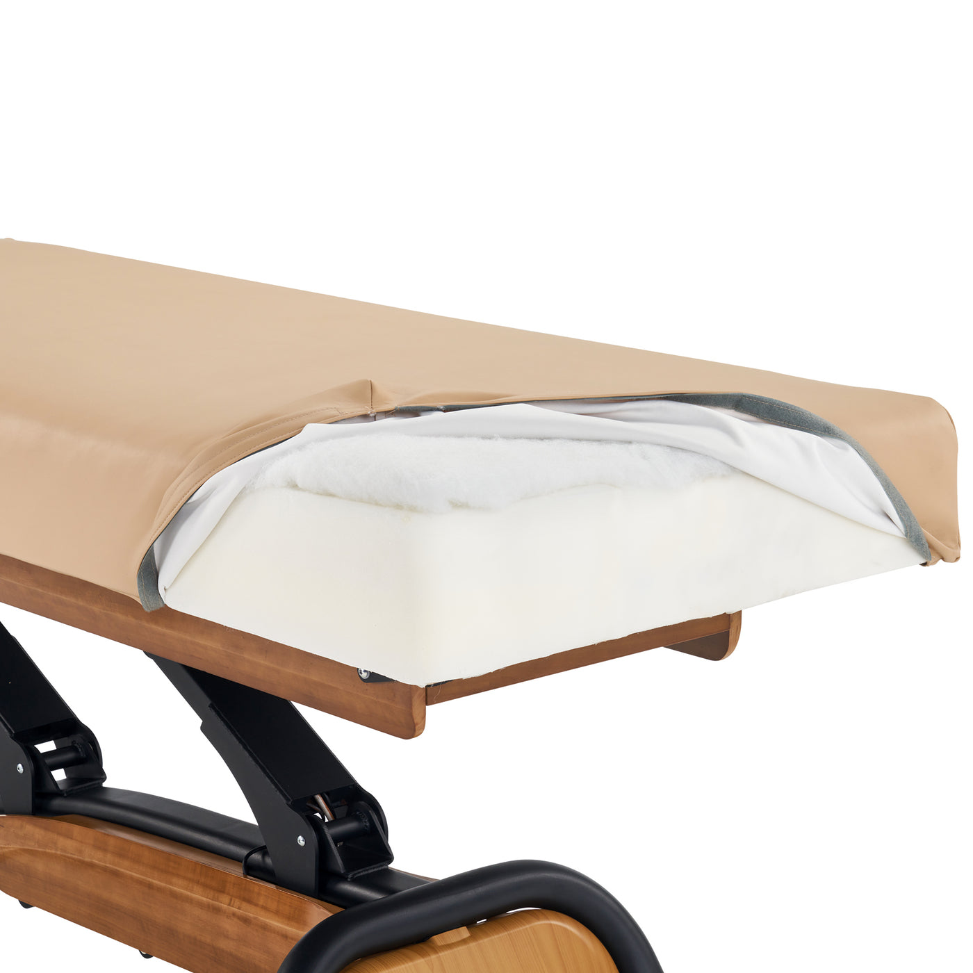 The Master Massage Atlas Deluxe spa bed with its cover pulled back reveals layered foam cushioning.
