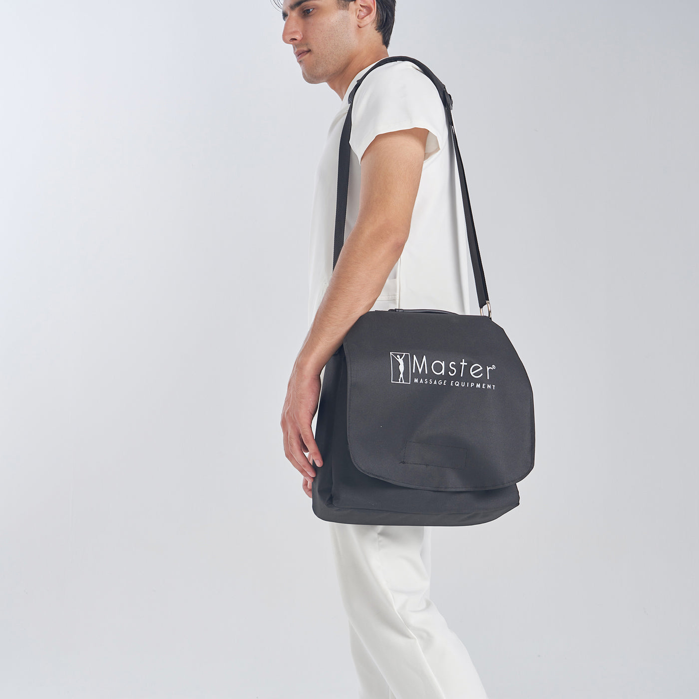 Person holding a black bag with 'Master' logo on a white background