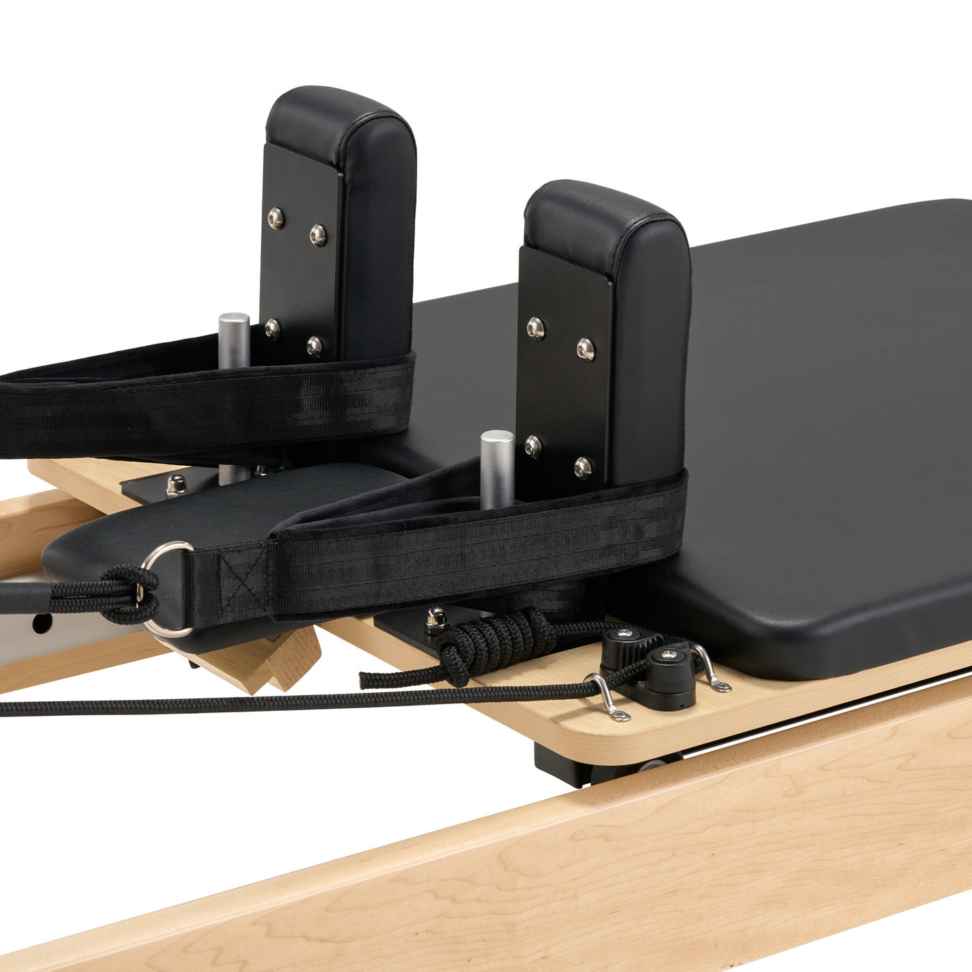 Pilates reformer machine with wooden base and black padding on a white background