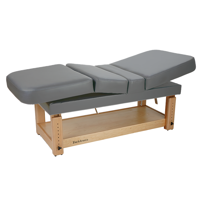 TouchAmerica STATIONARY MULTIPRO Treatment Table with segmented cushioned surface and wood base.