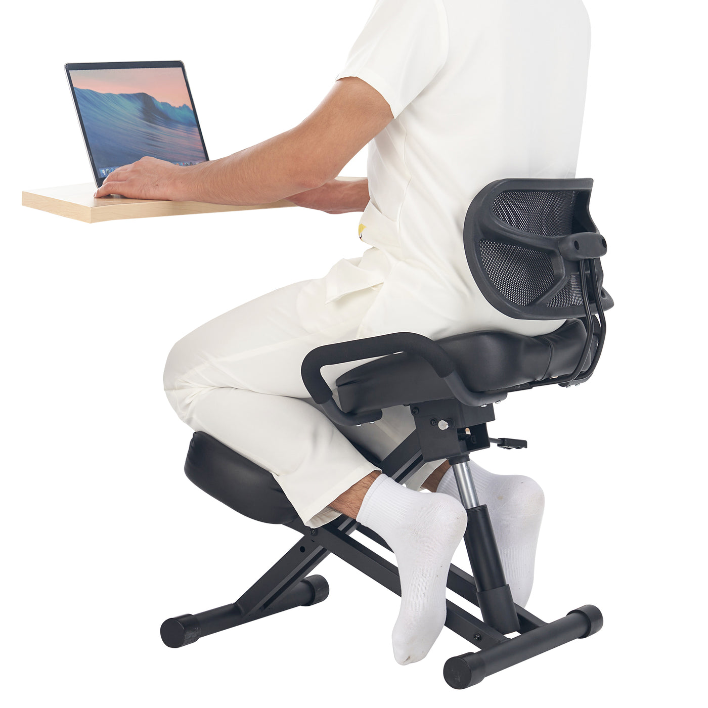 A person uses the Master Massage Ergonomic Kneeling Chair with Back Support at a wooden desk.