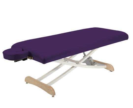 Purple massage table with wooden legs on a white background
