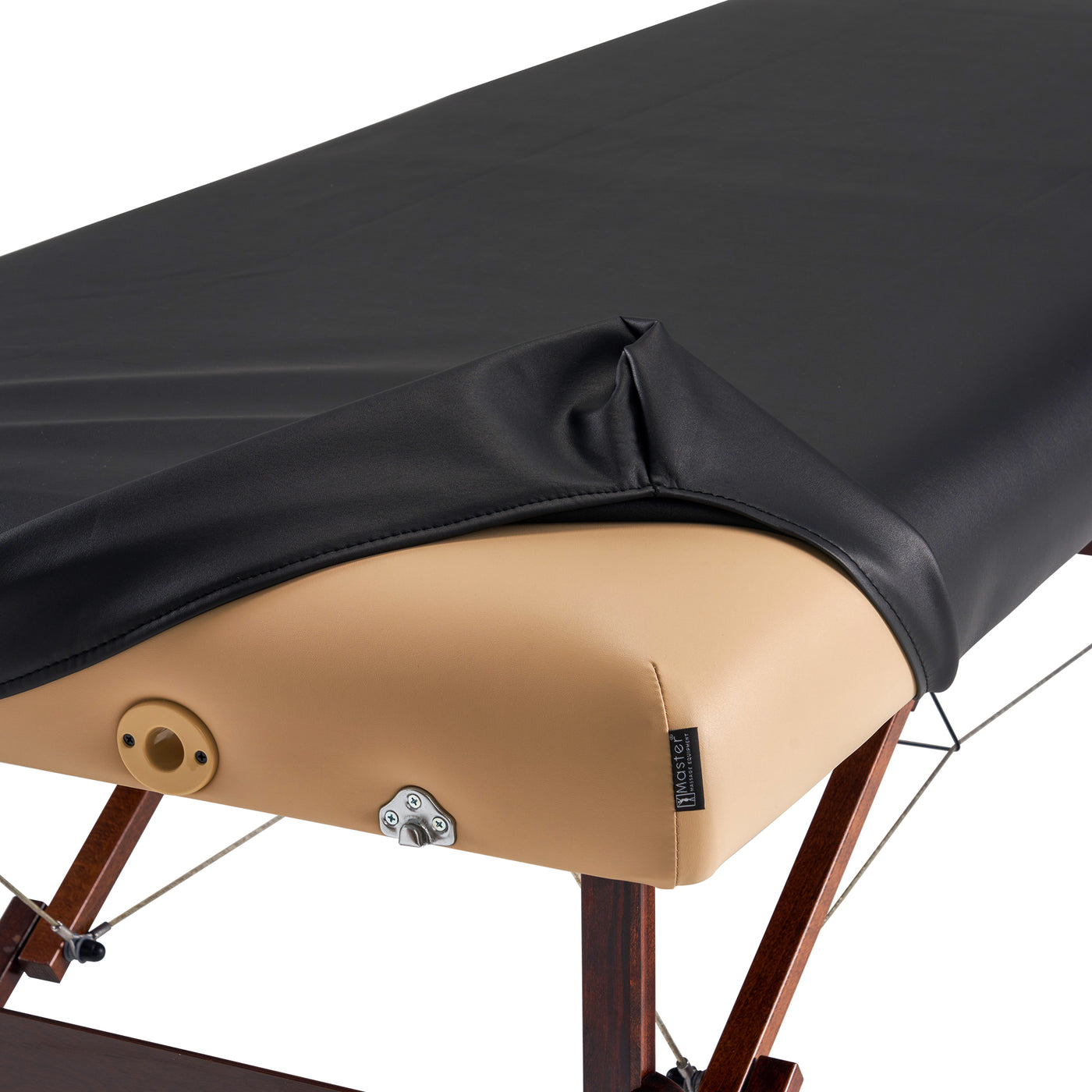 Massage table with black cover and beige cushion on a white background