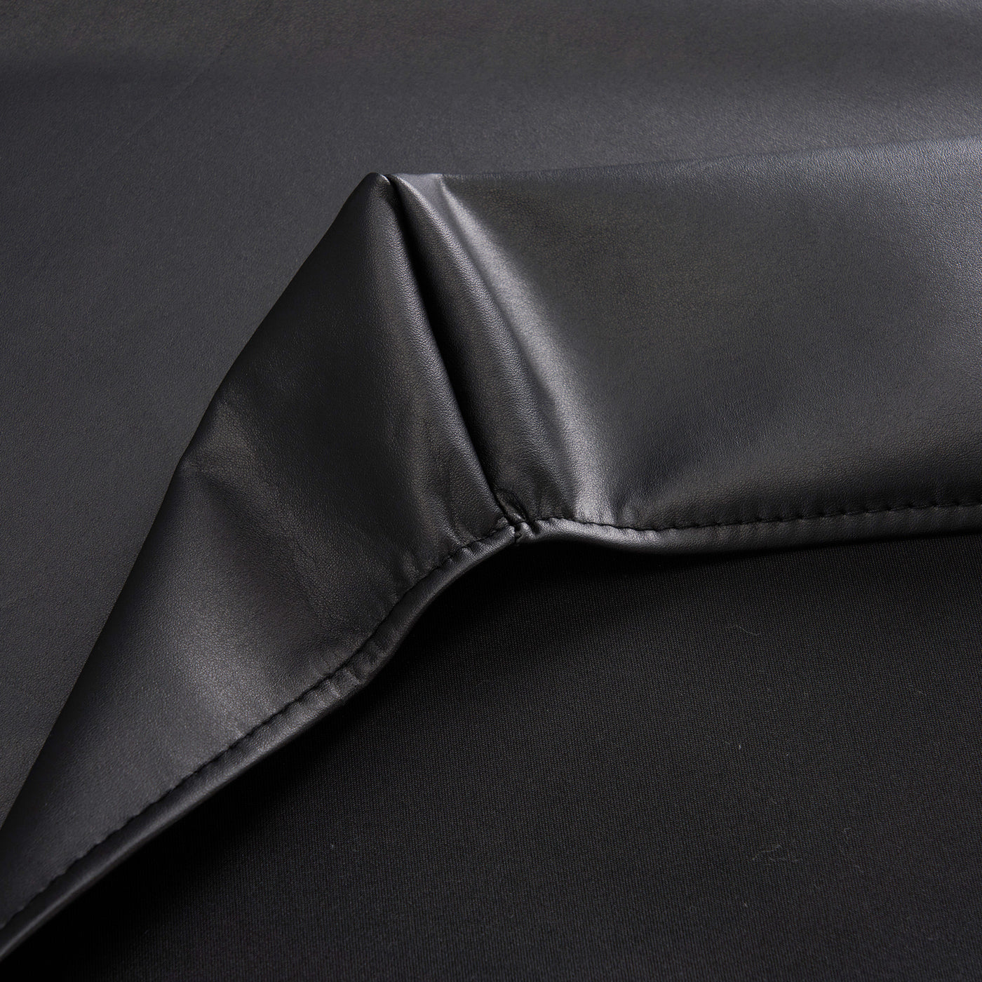 Close-up of black fabric with a slight texture on a dark background
