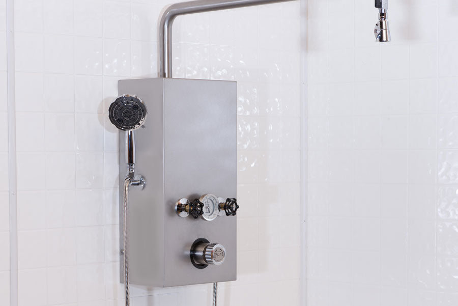 Water Werks Cascade 5 Head Vichy Shower with 85” arm and control panel on tiled wall.